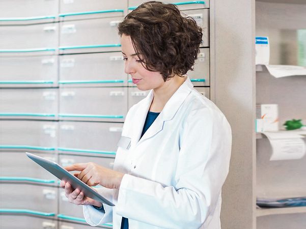 Apothekerin sieht sich die Telematik Lösung auf Ihrem Tablett an