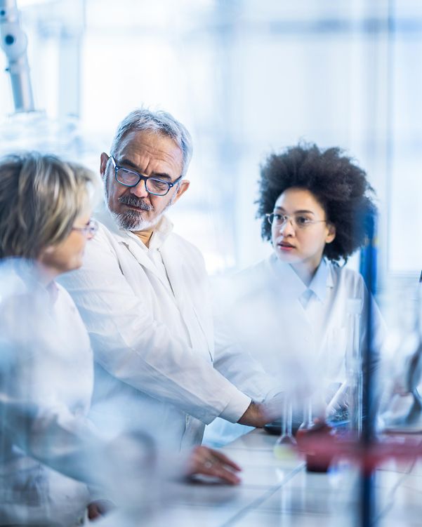 Gruppe von Wissenschaftlern, die während der Zusammenarbeit im Labor kommunizieren.