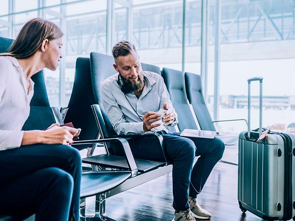 Mann zeigt Frau am Flughafen FreeMove Business.