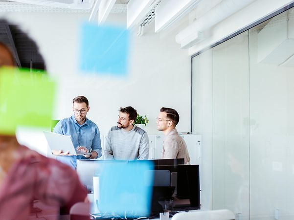 Kollegen erarbeiten sich am Laptop Strategien mit Microsoft Copilot