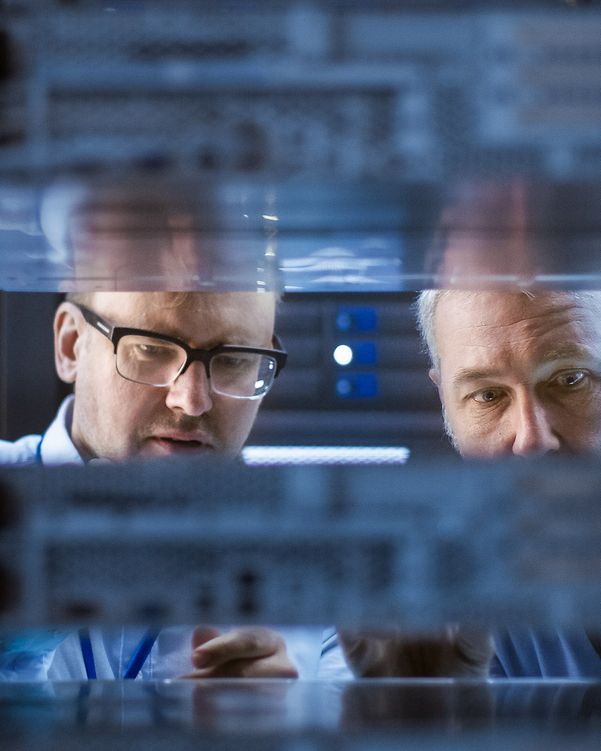 Zwei Männer schauen in einen Serverschrank der Telekom