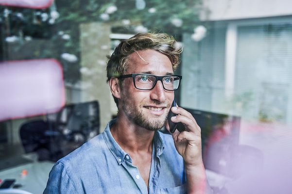 Mann nimm am Handy Kontakt bezüglich der FreeMove-Allianz auf.