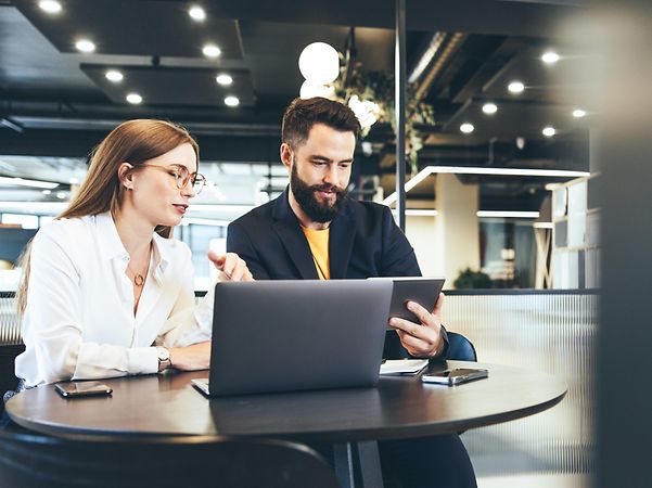 Zwei Personen arbeiten mobil an einem öffentlichen Ort mit Managed Workplace