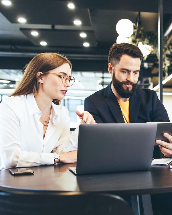 Zwei Personen arbeiten mobil an einem öffentlichen Ort mit Managed Workplace