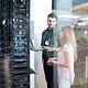 Zwei Personen unterhalten sich vor einem großen Serverschrank über das Managed IT-Portfolio der Telekom