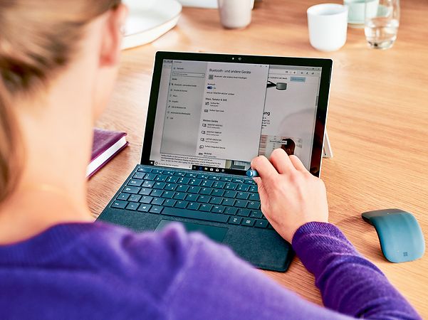 Eine Frau informiert sich am Laptop über Managed Backup to Cloud