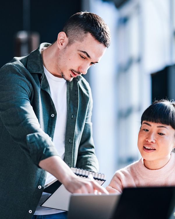 Junge Berufstätige arbeiten in modernen Co-Working-Spaces zusammen