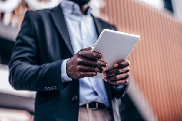 Mann liest auf Tablet zum Thema mobiler Sicherheit mit VPN.