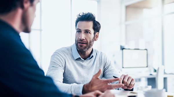 Zwei Männer unterhalten sich über das Verwalten von eSim Profilen.