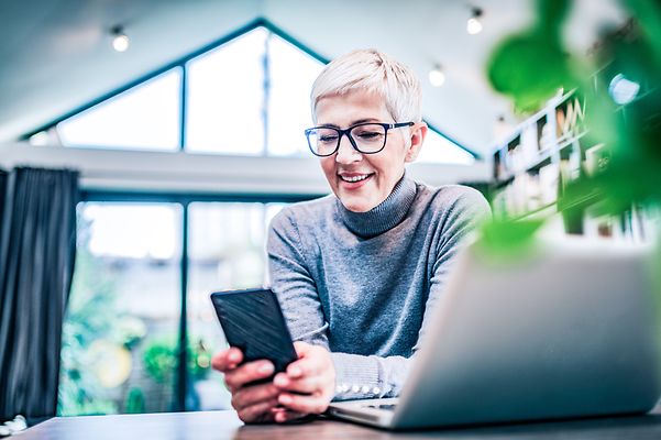 Eine Frau schaut im Büro auf ihr Smartphone