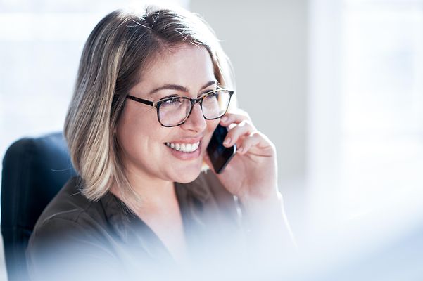 Aufnahme einer jungen Geschäftsfrau, die in einem Büro auf einem Mobiltelefon spricht