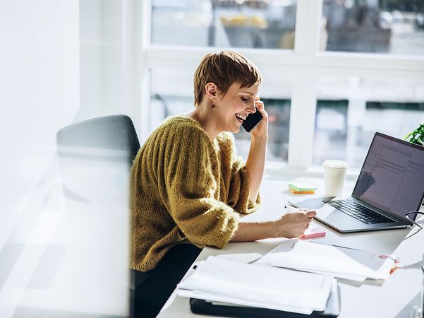 Frau telefoniert mit einem Telefon für CloudPBX-Anlagen