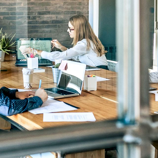 Mehrere Kollegen sitzen an einem großen Besprechungstisch und diskutieren über die MagentaBusiness Cloud.