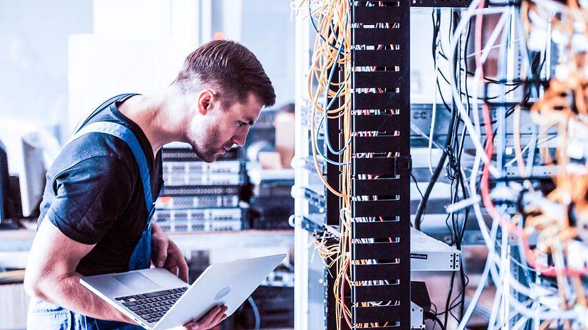 Ein Mann kontrolliert mehrere Kabel.