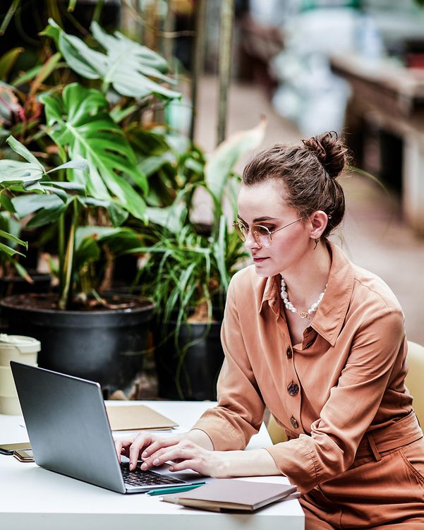 Junge Designerin eines kleinen Unternehmens, arbeitet am Laptop im Cafe und informiert sich über Cloud Infrastructure