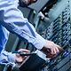 Hände eines Mannes im Businesshemd bedienen einen Serverschrank