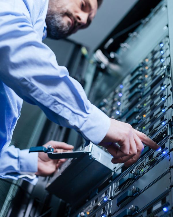 Hände eines Mannes im Businesshemd bedienen einen Serverschrank