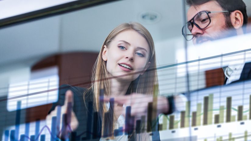 Busienss Analytics Zwei Geschäftsleute vor futuristischem Display analysieren Daten