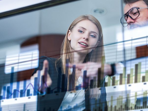 Busienss Analytics Zwei Geschäftsleute vor futuristischem Display analysieren Daten