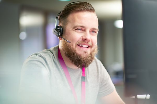 Serviceberater der Telekom lächelt mit Headset