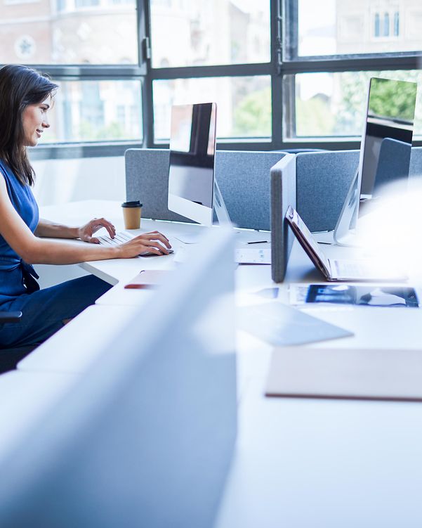 Junge Frau nutzt die intelligente TeamDesk-Funktion von XPhone Connect im Büro.