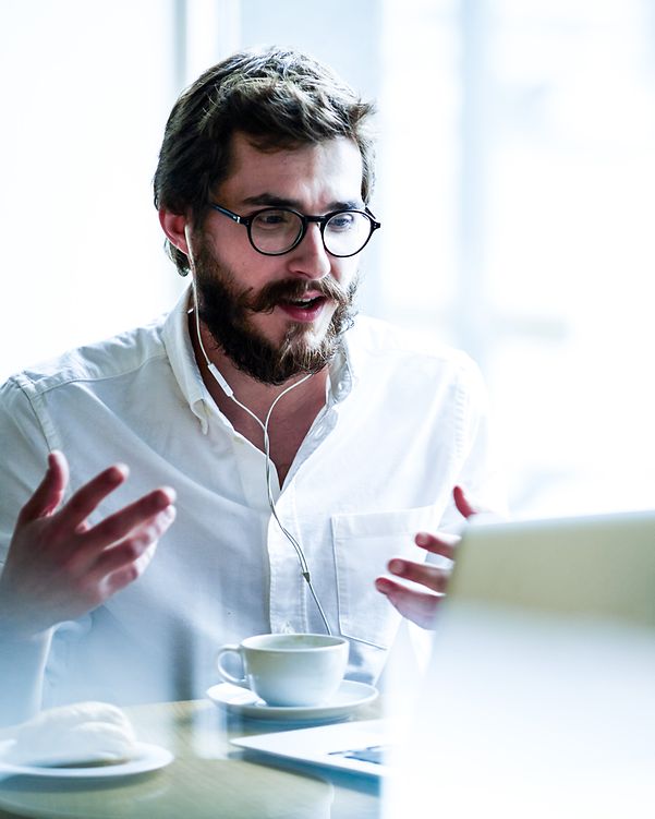 Business Analytics Mann sitzt hinter seinem Laptop in eine digitalen Konferenz