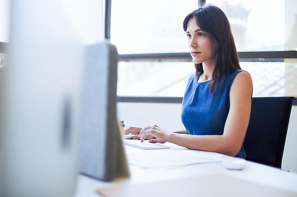 Frau sitzt im Büro an einem Computer