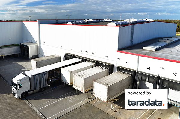Mehrere LKW stehen vor Lagerhallen und die TeraData Lösung sorgt dafür dass keine Leerfahrten entstehen