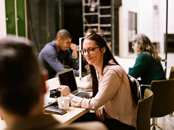 Mitarbeiter sitzen in einem Meetingtisch und freuen sich über CompanyFlex Services.
