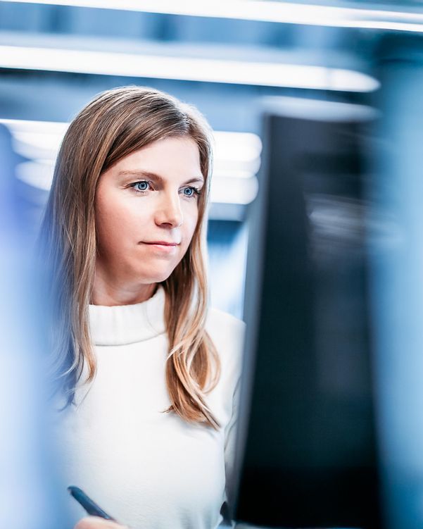 Junge Frau nutzt kuenstliche Intelligenz an ihrem Rechner.