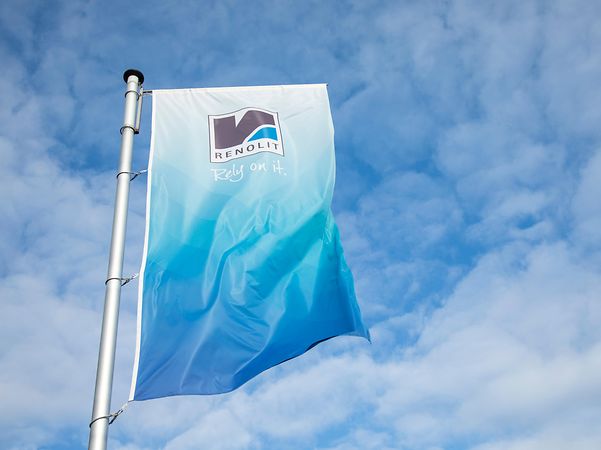 blauweisse Unternehmensfahne mit Schriftzug von RENOLIT weht am Mast