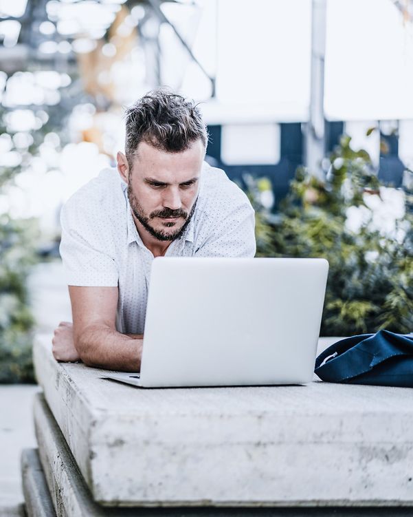 Ein Mann freut sich, weil das mobile Arbeiten mit seinem Laptop dank Digital Office Service reibungslos funktioniert.