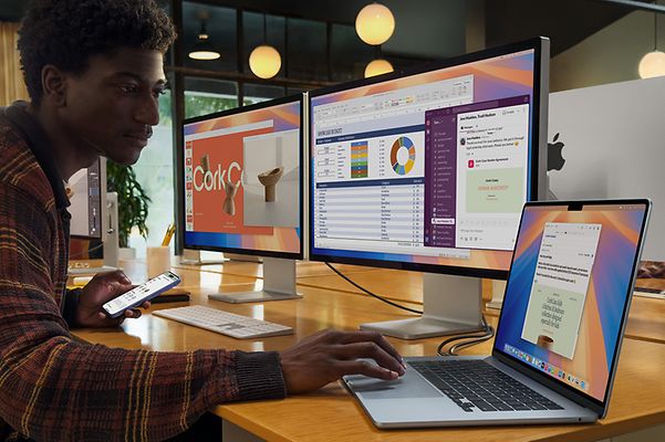Mann ist im Büro und nutzt ein MacBook