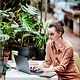 Frau arbeitet remote im grünen Umfeld – modernes Arbeiten mit Fokus auf T Business Nachhaltigkeit