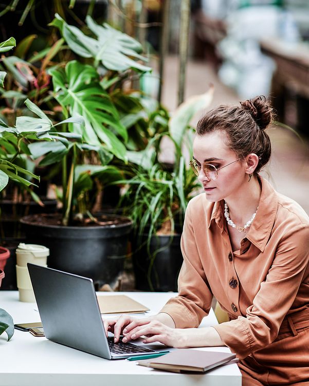 Frau arbeitet remote im grünen Umfeld – modernes Arbeiten mit Fokus auf T Business Nachhaltigkeit