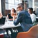 Kollegiales Teammeeting mit Fokus auf T Business Partnerschaftlichkeit in modernem Konferenzraum