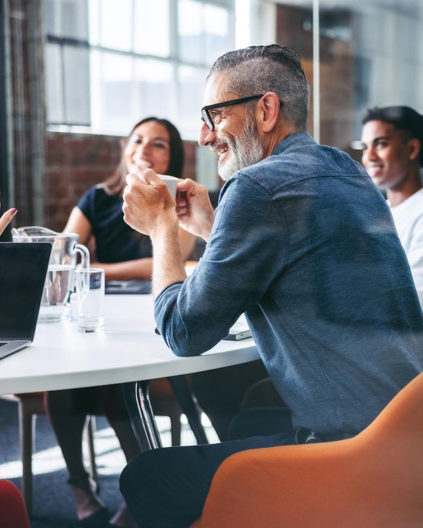 Kollegiales Teammeeting mit Fokus auf T Business Partnerschaftlichkeit in modernem Konferenzraum
