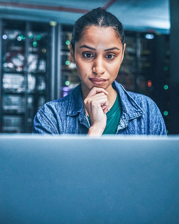 Eine Frau sitzt vor ihrem MacBook und informiert sich über die Apple Sicherheitsfeatures