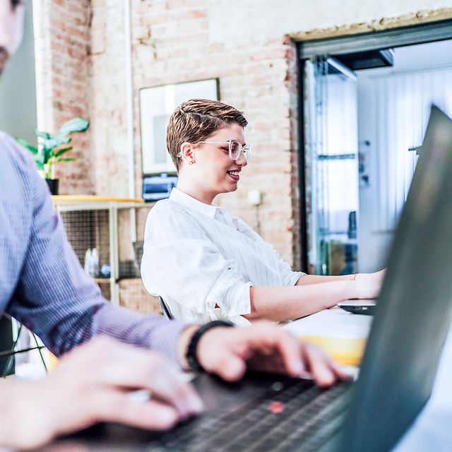 Zwei Menschen arbeiten in einem Büro am Laptop