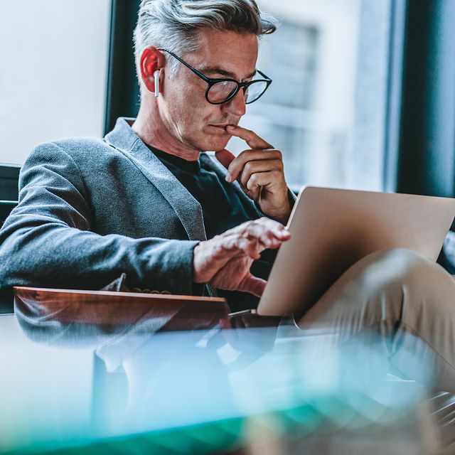 Geschäftsmann vertieft sich in digitale Fachinhalte am Laptop – Know-how & Insights von T Business