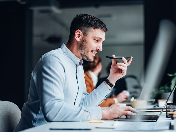 Geschäftsmann nutzt CompanyFlex Cloud PBX für den standortübergreifenden Austausch mit Kollegen.