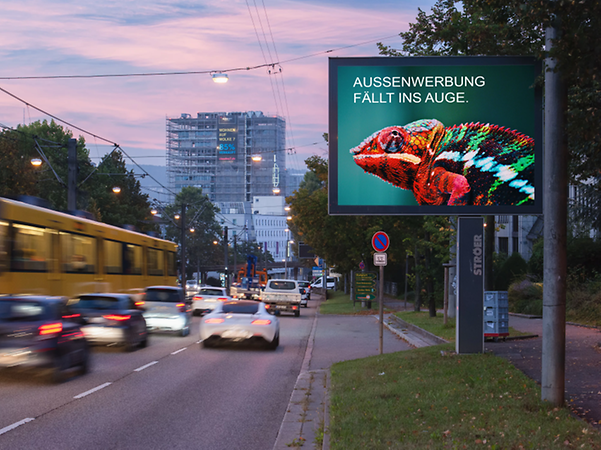 Bild zeigt ein beleuchtetes Citylight auf einer befahrenen Hauptstraße in Stuttgart während der frühen Abendstunden