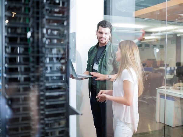 Zwei Security-Experten vor einem Serverschrank beraten sich zu Strategic Security Services