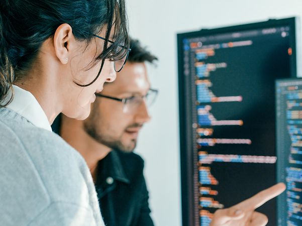 Ein Spezialistenteam für Cybersecurity berät sich vor einem PC-Bildschirm