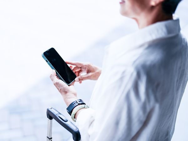 Ein Mann hält sein Handy in der Hand.