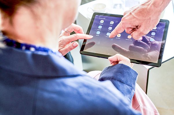 Geschäftskunde informiert sich über die Open Telekom Cloud auf dem Tablet.
