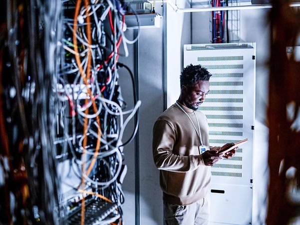 Ein Techniker steht vor einem Serverschrank der Telekom