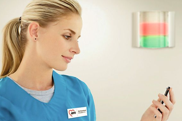 Pflegerin registriert einen Lichtruf auf ihrem Smartphone