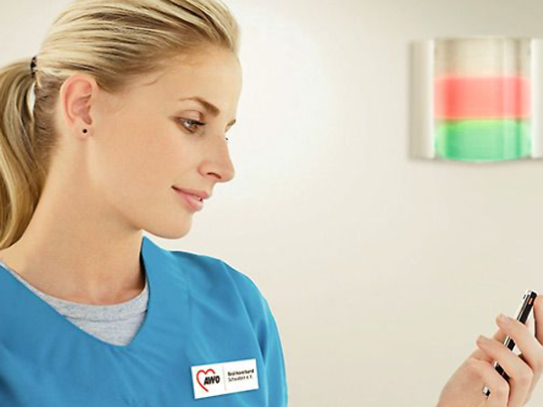 Pflegerin registriert einen Lichtruf auf ihrem Smartphone